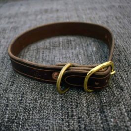 A brown handmade leather dog collar with two brass buckles.