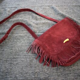 A Frontier Suede Saddlebag sitting on top of a gray blanket.