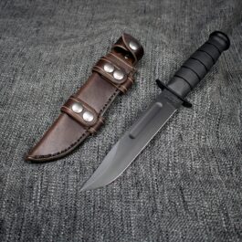 A Leather Scout Sheath for the Ka Bar Fighting Knife on a gray cloth.