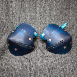 a pair of blue leather mittens sitting on top of a couch.