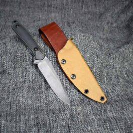 a Benchmade Protagonist with a Kydex sheath sitting next to it.