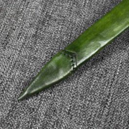 A Custom Leather Scabbard laying on top of a gray carpet.