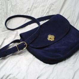 a Frontier Suede Saddlebag with a gold flower on it.