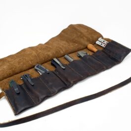 A Handmade Leather Knife/Tool Roll with a knife set inside of it.