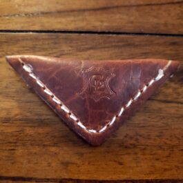 A brown leather Handmade Leather Finger Football with white stitching on a wooden surface.