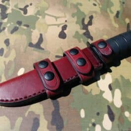 A Leather Scout Sheath for the Ka Bar Fighting Knife on a camouflage background.