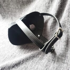a Handmade Leather Plague Doctor Mask laying on top of a gray blanket.
