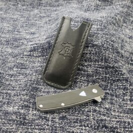 A Leather Pocket Slip for the Benchmade Tengu laying on top of a piece of cloth.