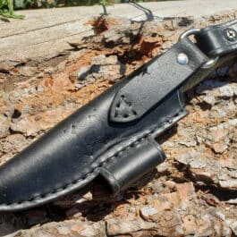 a knife is laying on a piece of wood.