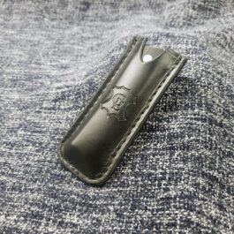 A black Leather Pocket Slip for the Benchmade Tengu sitting on top of a gray blanket.