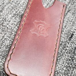 A Leather Pocket Slip for the Benchmade Tengu sitting on top of a carpet.