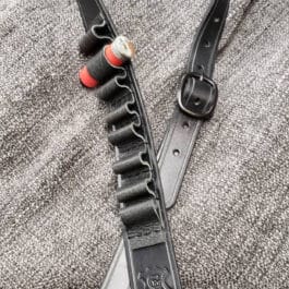 A black Handmade Leather Rifle Sling with ammo loops laid on a cloth - Grommet's Leathercraft - renaissance clothing - renaissance art clothing - renaissance era clothing - leathercraft supplies - leathercraft accessories - leathercraft store near me - quality leather craft