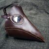 brown Handmade Leather Plague Doctor Mask laid on a cloth - renaissance clothing - renaissance clothing men - renaissance clothing women - renaissance clothing near me - renaissance art clothing - renaissance era clothing - renaissance costume ideas