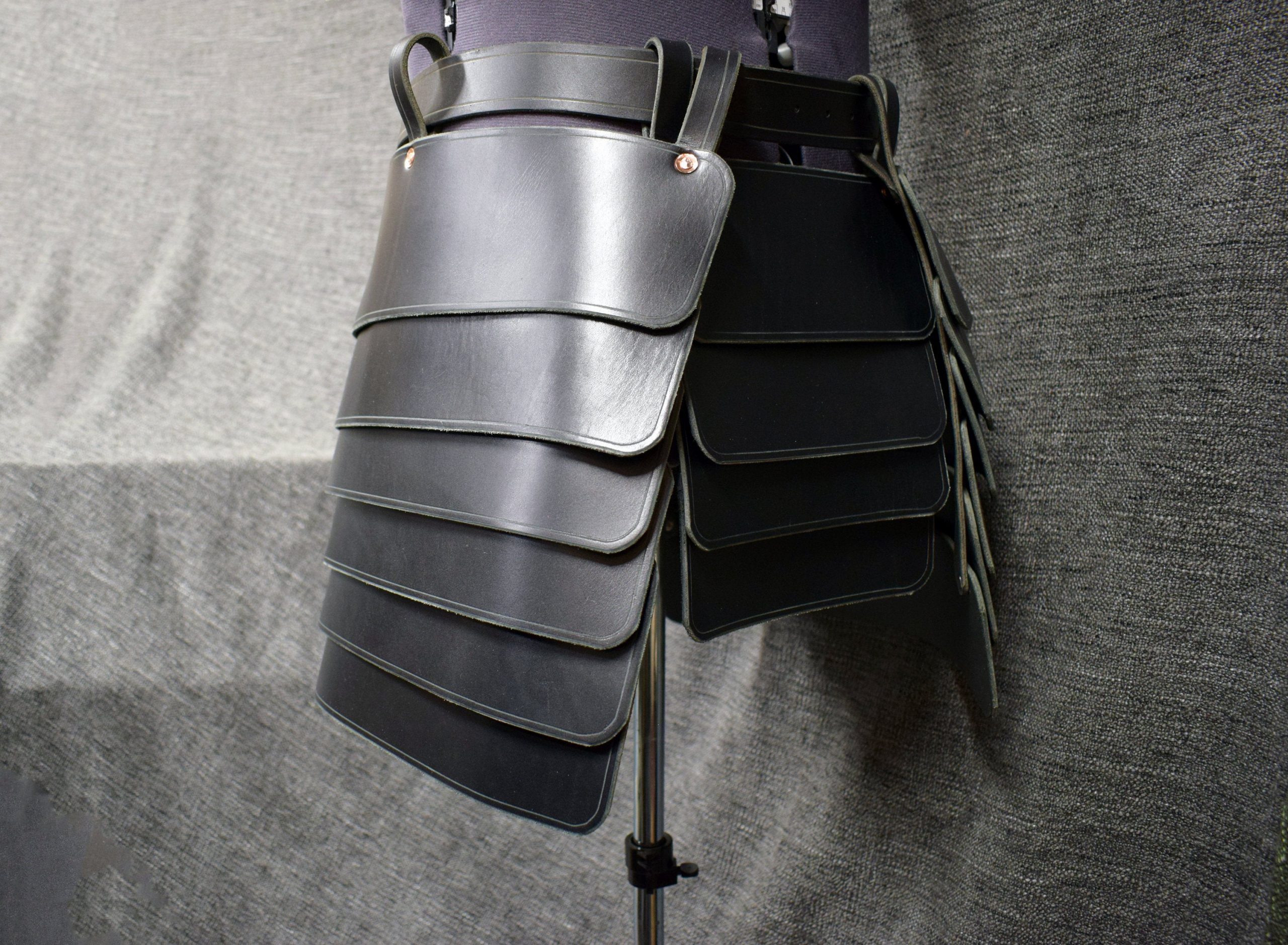 a black leather purse hanging on a wall.