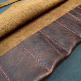 A Handmade Leather Knife/Tool Roll sitting on top of a table.
