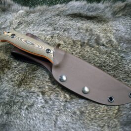 a Benchmade Saddle Mountain Skinner Kydex Sheath laying on top of a fur covered surface.