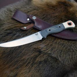 a knife on top of a fur covered surface.