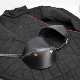 A close up of a Simple Leather Elbow Armor on a black cloth.