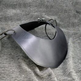 black Leather Mantle Gorget laid on a table - renaissance clothing - renaissance clothing men - renaissance clothing women - renaissance clothing near me - renaissance art clothing - renaissance era clothing - renaissance costume ideas