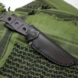 A Handmade Leather Sheath for the Benchmade Fixed Adamas is laying on a green cloth.