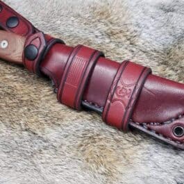 a Handmade Leather Scout Sheath For The TOPS Fieldcraft Knife on a furry surface.