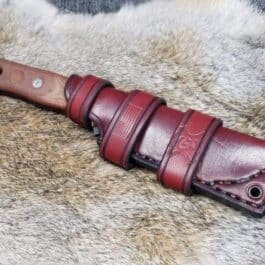 A Handmade Leather Scout Sheath for the TOPS Fieldcraft Knife laying on a fur rug.
