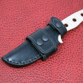 a Benchmade Fixed Adamas knife with a Handmade Leather Sheath on a red surface.