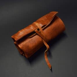 A Handmade Leather Knife/Tool Roll on a black surface.