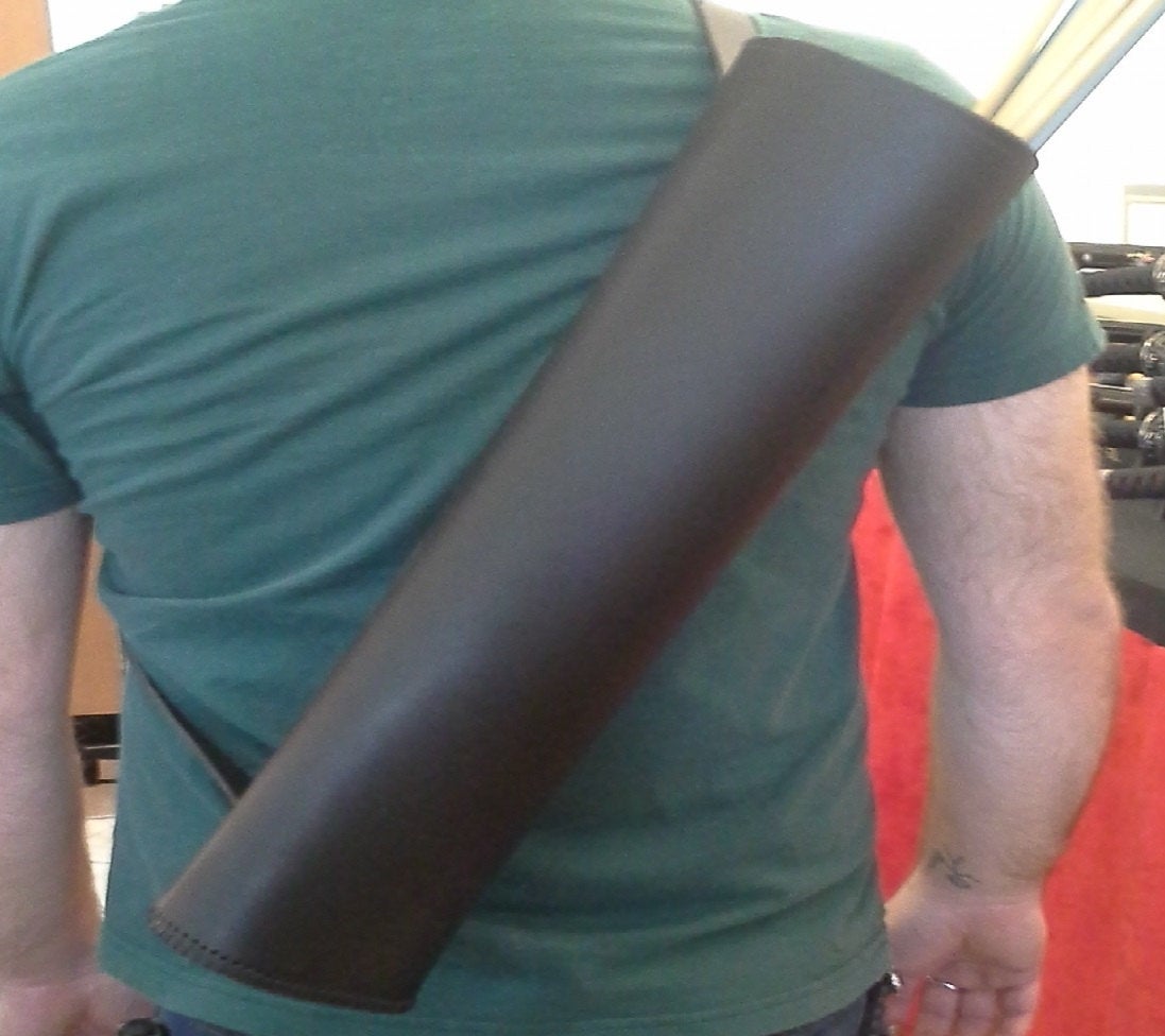 A man holding a large black Basic Back Quiver on his back.