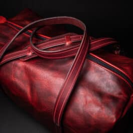 A Bison Leather Duffel Bag on a black background.