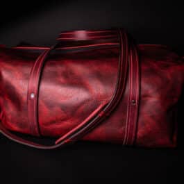 A Bison Leather Duffel Bag on a black background.