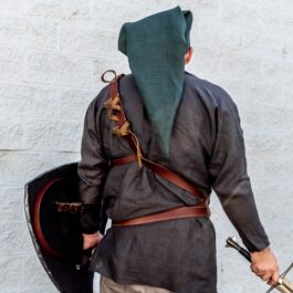 a man dressed in medieval clothing holding a sword and shield. (No replacement is possible as 