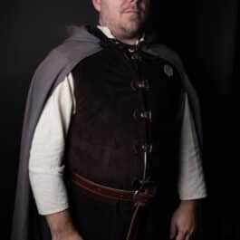 A man in a Wool Hooded Cloak standing in a dark room.
