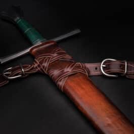 A Custom Wood Core Scabbard with a leather sheath on a black background.