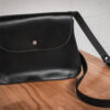 The "Serenity" purse sitting on top of a wooden table.