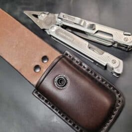 A Molded Leather Multi Tool pouch sitting on top of a leather case.