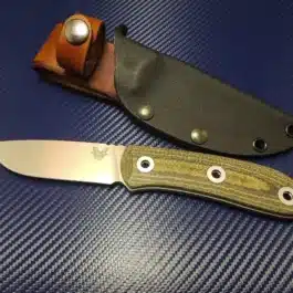 A Kydex sheath for the Benchmade Pardue Hunter on a blue surface.