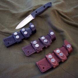 A Scout Style Leather Sheath for the Benchmade Bushcrafter laying on a cloth.