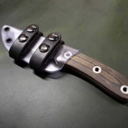 A Kydex Sheath for the Benchmade Pardue Hunter that is sitting on a table.