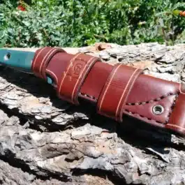A Scout Style Leather Sheath for the Benchmade Bushcrafter on a rock.