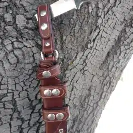 a Scout Style Leather Sheath for the Benchmade Bushcrafter attached to a tree.
