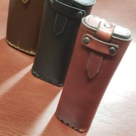 A handmade leather glasses case sitting on top of a wooden table.