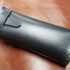 A Handmade Leather Glasses Case sitting on top of a wooden table.