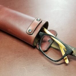 A pair of glasses sitting on top of a Handmade Leather Glasses Case.