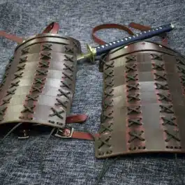 A pair of Samurai Style Shoulder Armor with a sword.
