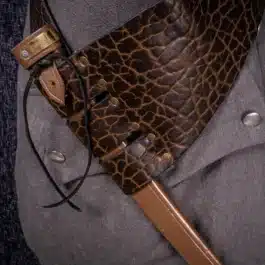 a person wearing a gray shirt and holding a Bison Leather Baldric.