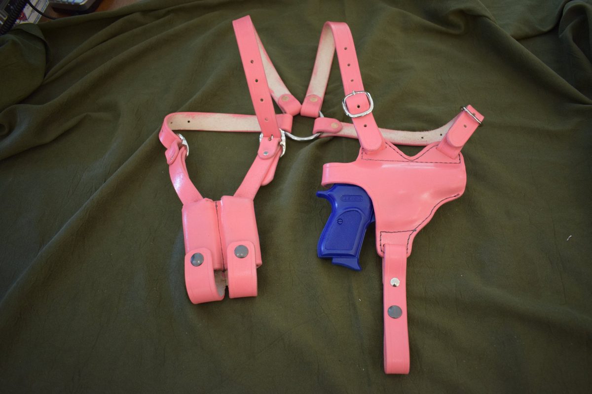 a pair of pink and blue holsters laying on a bed.