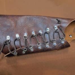 A Mirkwood Archers Vambrace with a bunch of metal clips attached to it.