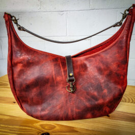 a Bison Leather Roll Top Rucksack sitting on top of a wooden table.