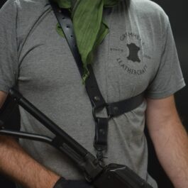 A man wearing a grey shirt and gloves with a black leather single point sling - Grommet's Leathercraft - renaissance clothing - renaissance art clothing - renaissance era clothing - leathercraft supplies - leathercraft accessories - leathercraft store near me - quality leather craft